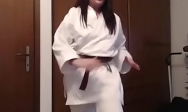 Giovane ragazza karateka suda und si allena mostrandoti il suo caldo corpo sudato